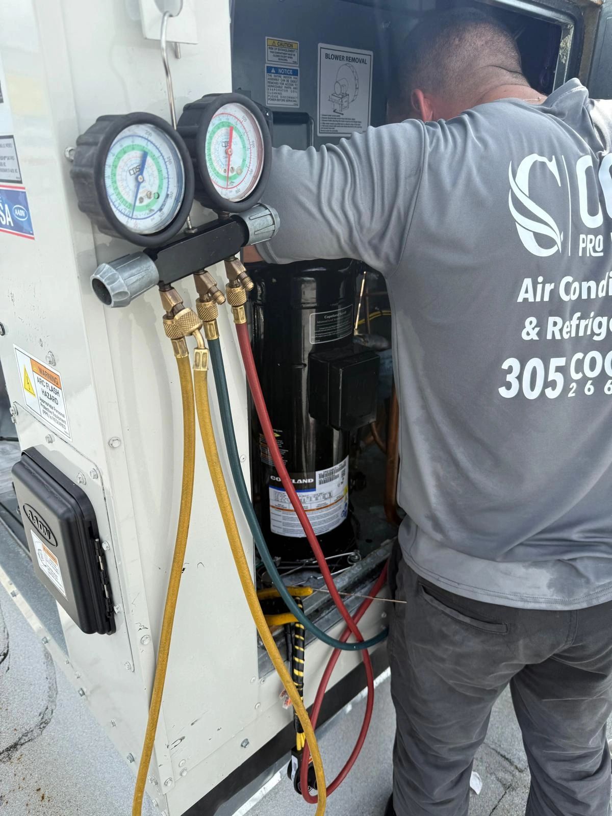 HVAC technician checking refrigerant pressure gauges
