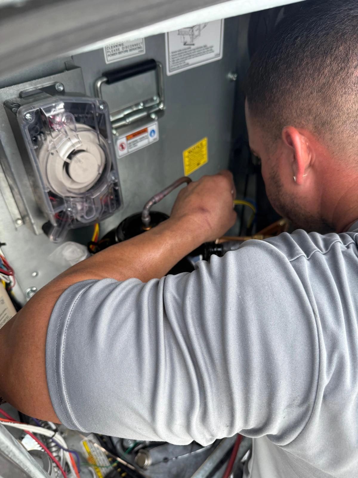 Technician performing HVAC system maintenance